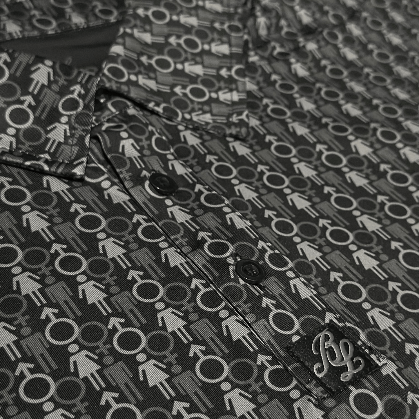 Men's 2 Genders Golf Shirt in black and grey. Close up of placket.