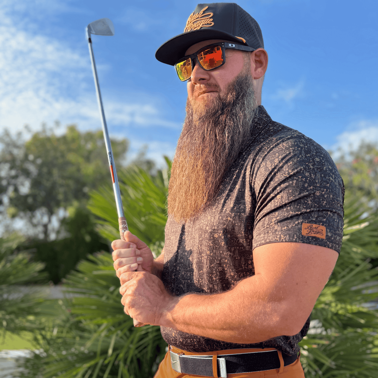 Men's Desert Golf Shirt in black and copper. Lifestyle image.